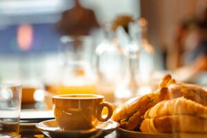 A plate of croissants beside a cup of coffee